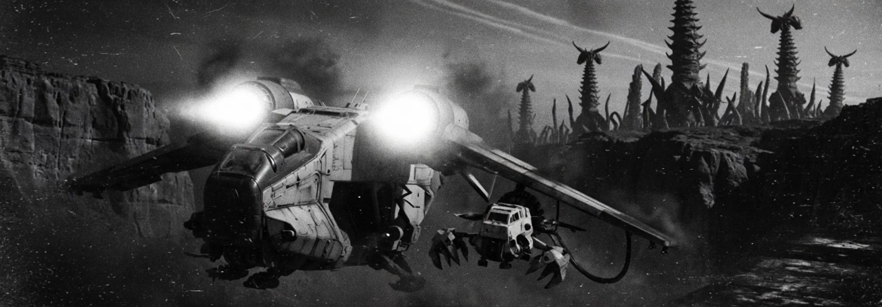 A gunship over an orange canyon with a scout clamped under the wing.