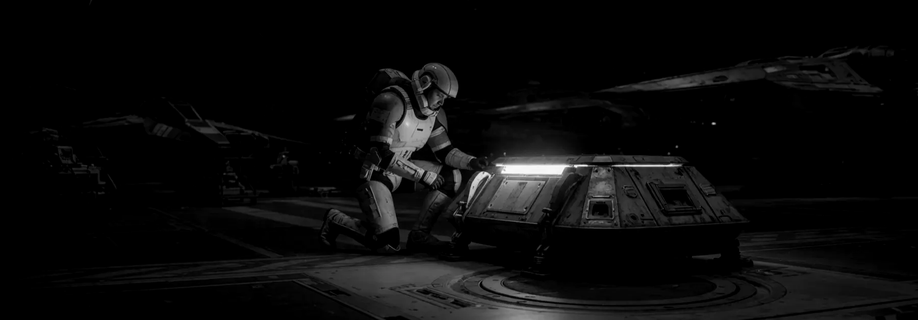 A technician kneels beside a small capsule that still glows after the hangar lights go out.